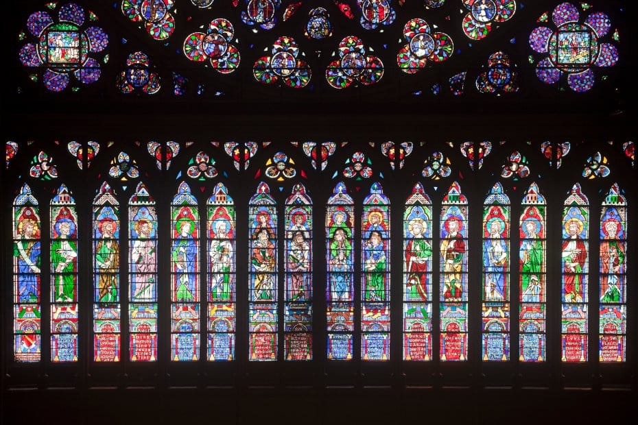 Un ensemble de vitraux de l'intérieur de la cathédrale Notre-Dame de Paris, la photographie en contre jour fait ressortir les couleurs vives