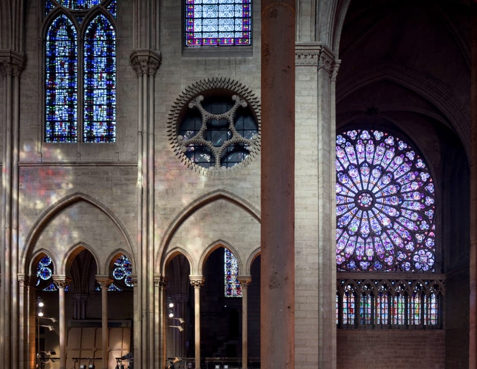 Dans Notre-Dame de Paris, vue d'ensemble des vitraux séparés par une colonne au premier plan de la photographie