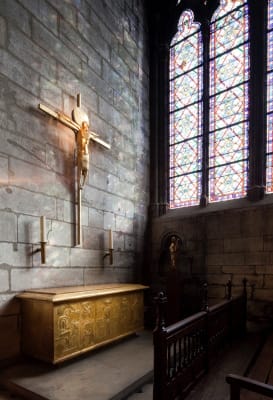 Un autel sculpté au dessus duquel se trouve deux chandeliers et un crucifix