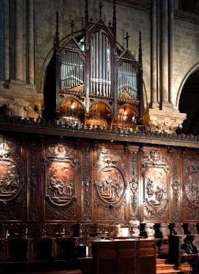 L'orgue de chœur situé au dessus des panneaux en bois des stalles