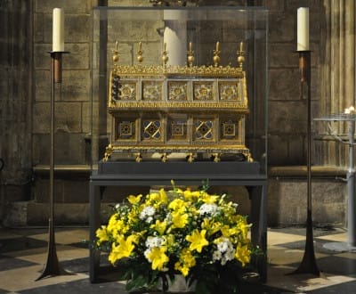 Les reliques et chasse de sainte Geneviève mises sous verre à l'intérieur de la cathédrale, décorées d'un bouquet de fleurs jaunes et blanches et entourées de deux chandeliers