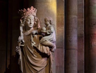 Statue de la Vierge à l'enfant baignée dans les couleurs reflétées par les vitraux